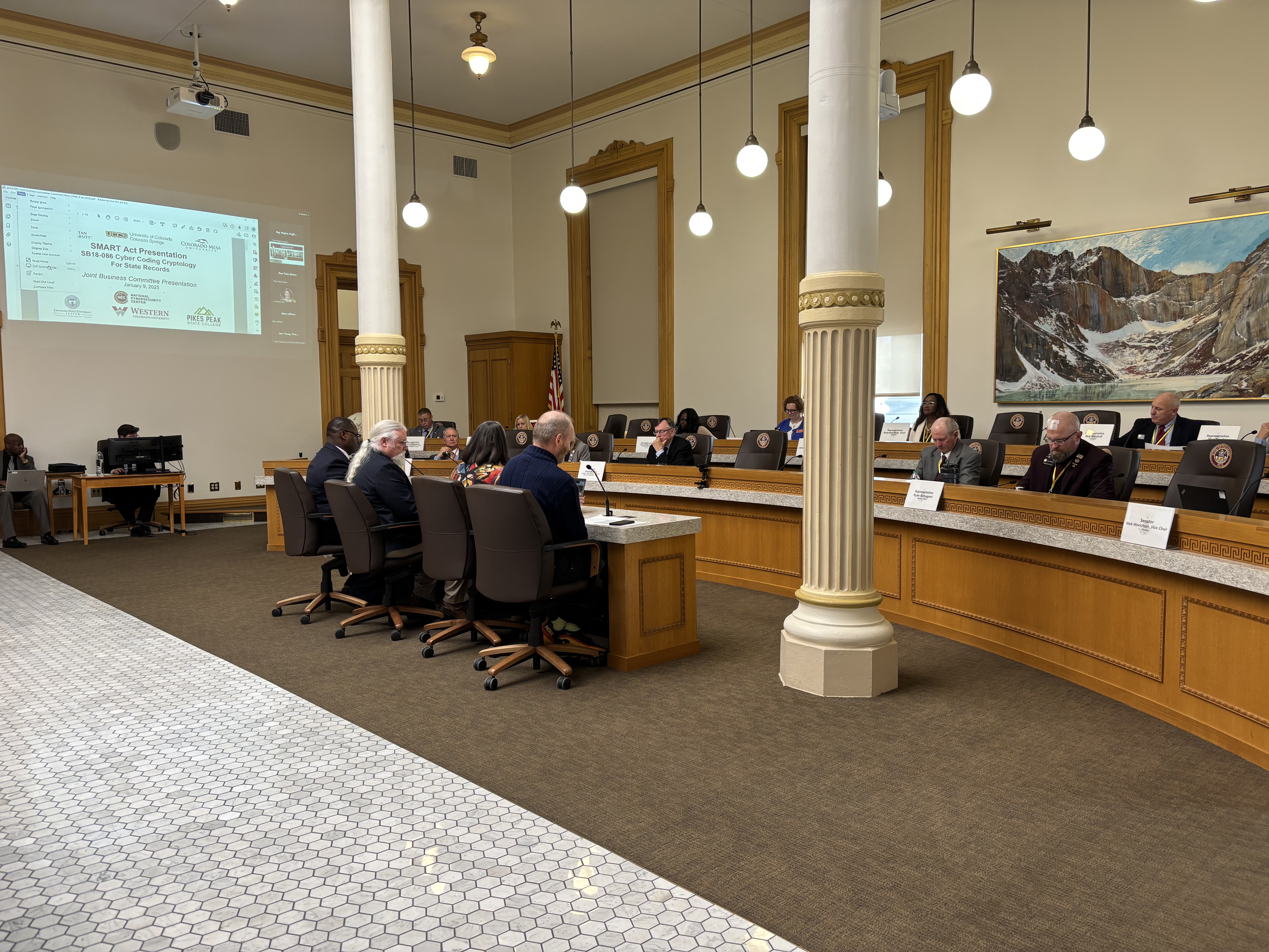 A group of four presenting at a state legislature conference room